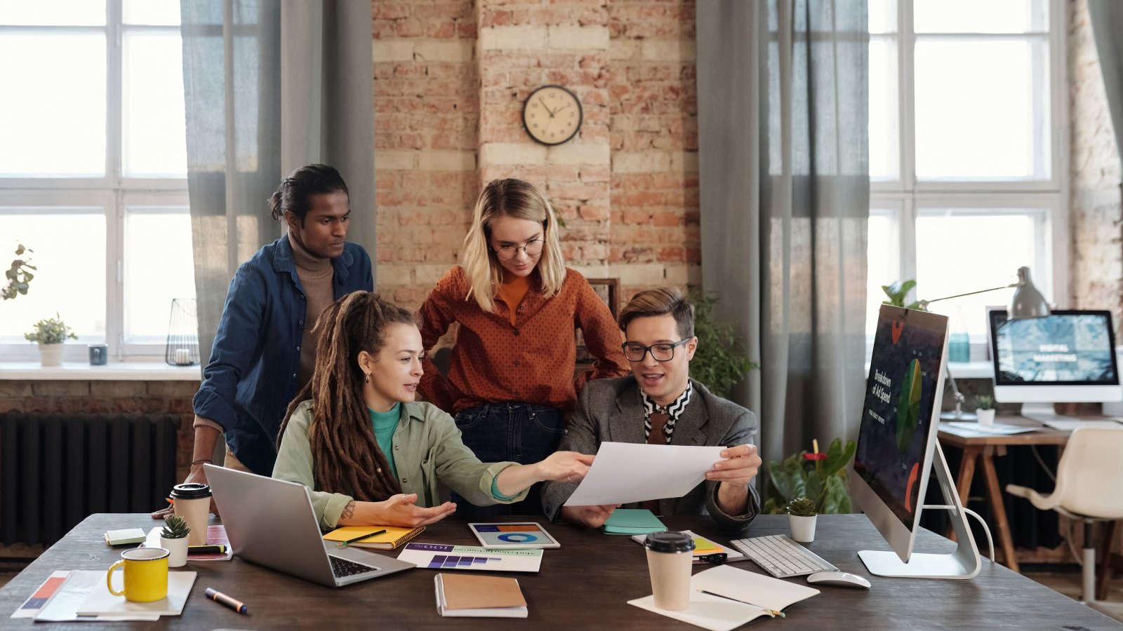 A diverse team of young professionals working on a business strategy in an urban office setting