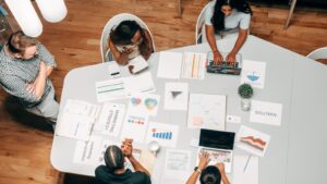 Diverse team collaborating on marketing strategies with charts and laptops in an office